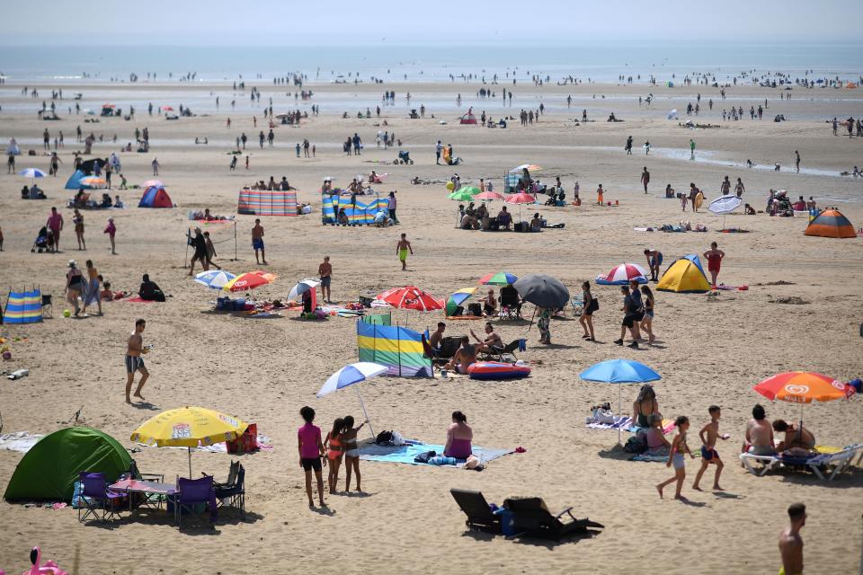 Beach-goers shelter enjoy the sunshine by the sea in Camber Sands, southern England on July 25, 2019, during a heatwave in Britain. (Photo by Ben STANSALL / AFP)        (Photo credit should read BEN STANSALL/AFP/Getty Images)
