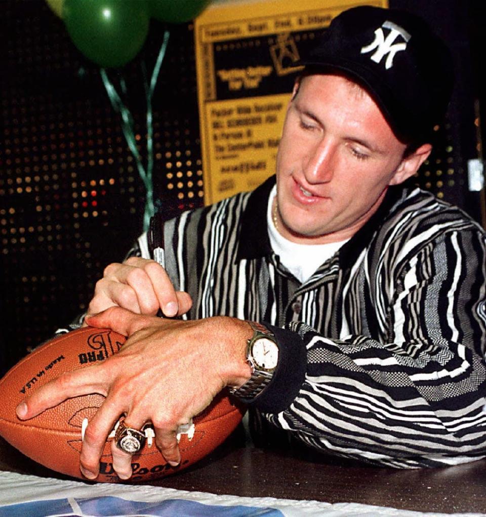 FILE - Sporting a Super Bowl Ring on his left hand, Green Bay Packer Bill Schroeder, autographs a football Tuesday night, Sept. 2, 1997, for a fan during an appearance at the CenterPoint Mall in Stevens Point, Wis.