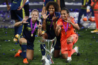 Lyon's Eugenie Le Sommer, Wendie Renard and goalkeeper Sarah Bouhaddi , from left to right, pose with the trophy after winning the Women's Champions League final soccer match between Wolfsburg and Lyon at the Anoeta stadium in San Sebastian, Spain, Sunday, Aug. 30, 2020. Lyon won 3-1. (Clive Brunskill/Pool via AP)