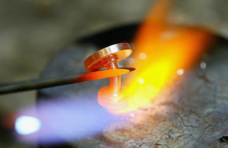 A jeweller uses a blow torch to heat up and repair a platinum cufflink in San Francisco, on March 26, 2004. Miner Anglo American has posted an annual net loss of $1.49 billion (1.11 billion euros) after taking a $4.6-billion hit on the value of its Minas-Rio iron-ore project in Brazil and platinum assets