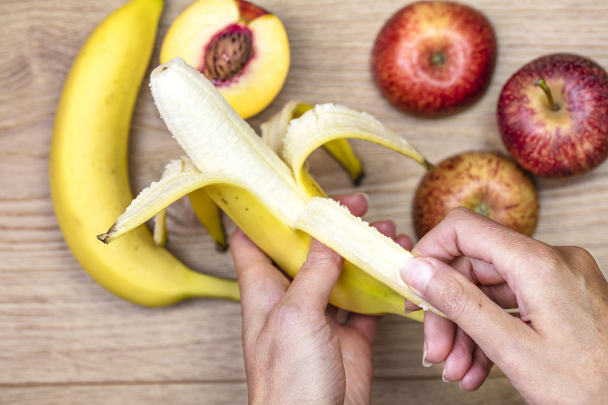 Woman peeling off banana  for healthy eating.