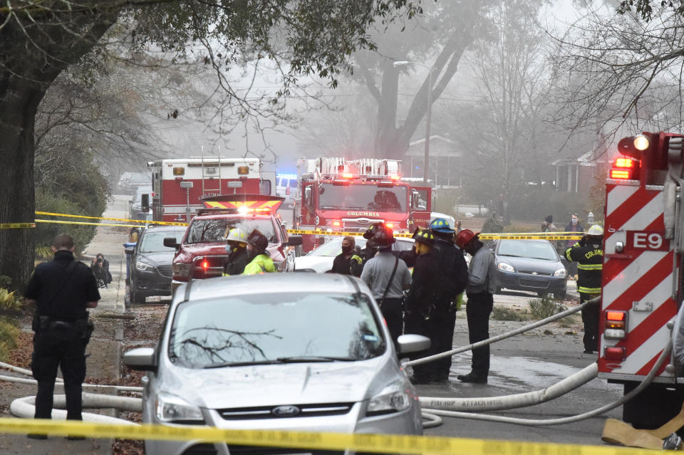 Officials clean up the scene following a small plane crash during dense fog in a residential neighborhood on Wednesday, Jan. 13, 2021, in Columbia, S.C. Authorities say the woman in the home was able to get out safely and have not given information on the condition of anyone aboard the plane. (AP Photo/Meg Kinnard)