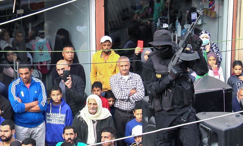 A Palestinian gunman carries a weapon during a funeral in Tyre