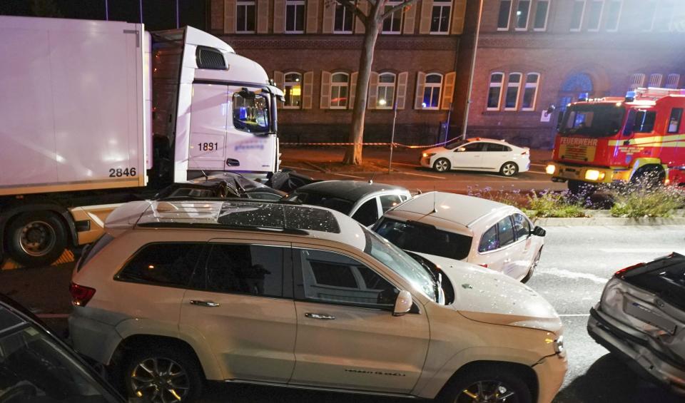 In this Monday, Oct. 7, 2019 photo s truck stands between damaged cars in Limburg, Germany. The truck drove into a line of eight cars in Limburg late Monday afternoon, pushing the vehicles into each other. Police said seven people were taken to hospitals and the driver also was slightly injured. He was detained. (Thorsten Wagner/dpa via AP)
