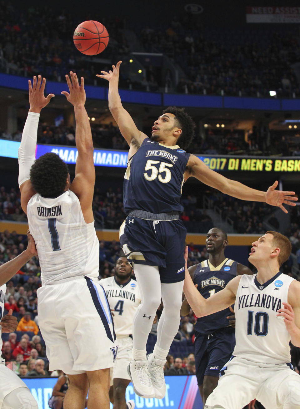 Mount St. Mary's Mountaineers guard Elijah Long (55) drives to the basket against Villanova Wildcats guard Jalen Brunson (1) and guard Donte DiVincenzo (10) during the first half of a first-round men's college basketball game in the NCAA Tournament, Thursday, March 16, 2017, in Buffalo, N.Y. (AP Photo/Bill Wippert)