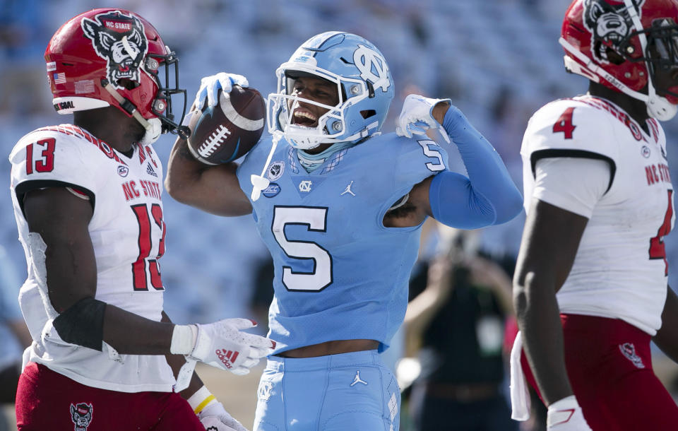 North Carolina's Dazz Newsome (5) celebrates in front of N.C. State's Tyler Baker-Williams (13) after a nine-yard gain in the third quarter of an NCAA college football game on Saturday, Oct. 24, 2020, in Chapel Hill, N.C. (Robert Willett/The News & Observer via AP)