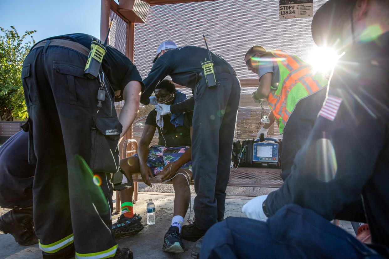 Firefighters from Phoenix Fire Engine 18 start a breathing treatment for a resident having trouble breathing during a heat wave in Phoenix on July 20, 2023. (Caitlin O'Hara / Bloomberg via Getty Images)