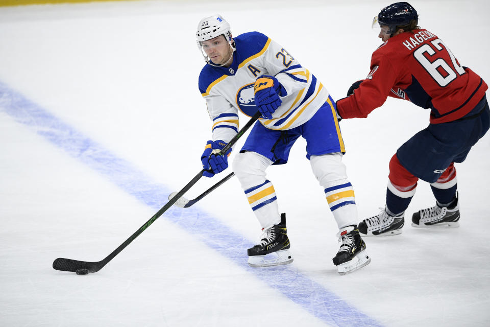 Buffalo Sabres right wing Sam Reinhart (23) skates with the puck past Washington Capitals left wing Carl Hagelin (62) during the second period of an NHL hockey game, Friday, Jan. 22, 2021, in Washington. (AP Photo/Nick Wass)