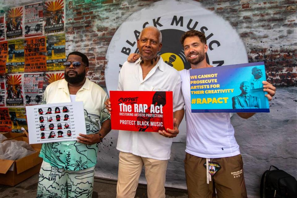 Black Music Action Coalition (BMAC) co-founder and chair​ Willie “Prophet” Stiggers, left, Congressmen Hank Johnson of Georgia, center, and festival co-founder Tariq Cherif, right, strike poses with signs reading ‘Support The Rap Act’ and ‘We Cannot Prosecute Artists For Their Creativity #RAPACT’ before a townhall to educate attendees about the Restoring Artistic Protection Act (RAP Act) on day one of Rolling Loud Miami 2023 at Hard Rock Stadium in Miami Gardens, Florida, on Friday, July 21, 2023.