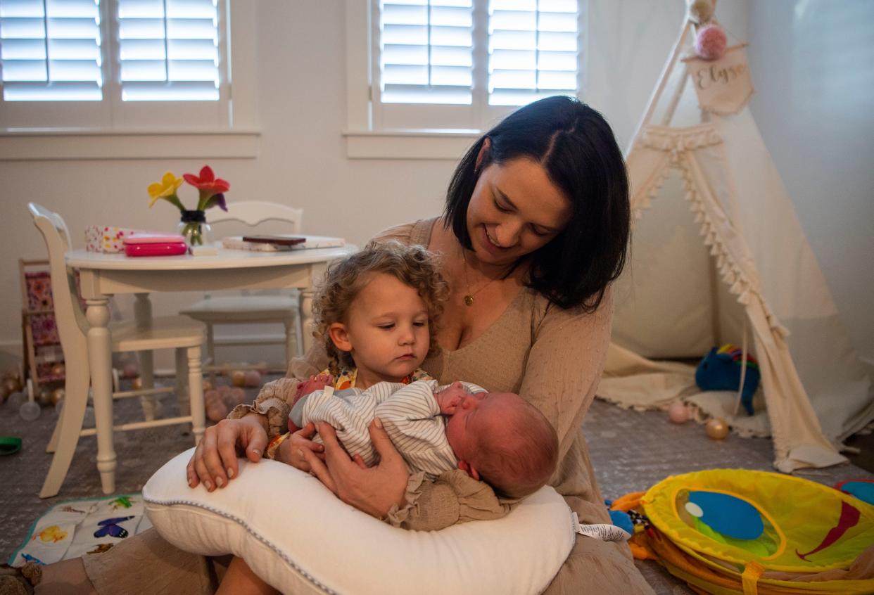 Jena Thomas and her daughter Elyse, hold Thomas' newborn son Jackson in their home at Nashville, Tenn., Thursday, Oct. 26, 2023. Thomas’s husband, Josh, tweeted a photo of his wife giving birth to their son in the parking garage at the Ascension Saint Thomas Hospital.