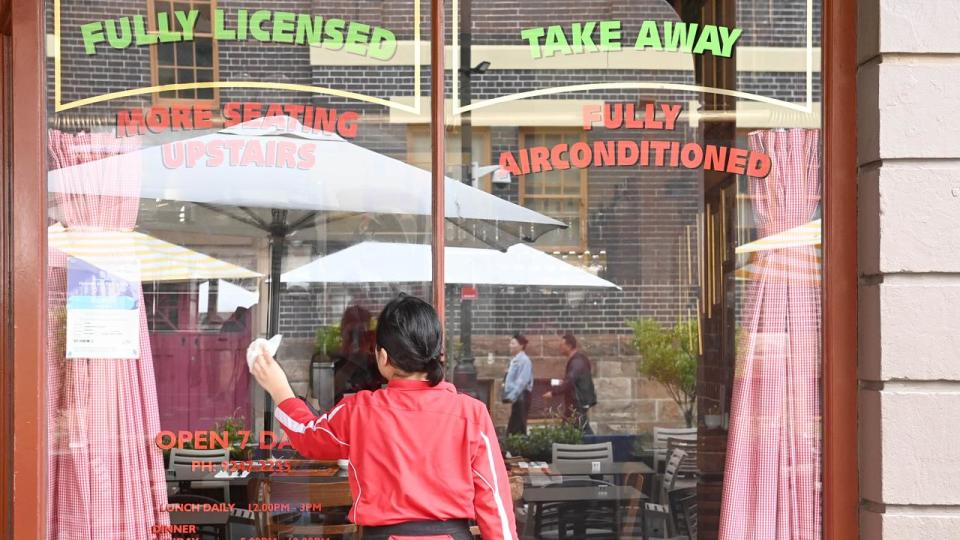 SYDNEY, AUSTRALIA - NewsWire Photos OCTOBER 22, 2022: A man washes down the window front at a cafe in the Rocks in Sydney. Picture: NCA NewsWire / Jeremy Piper