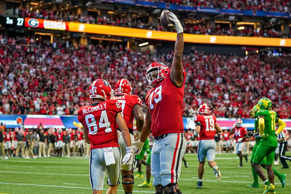 Georgia offensive lineman Xavier Truss (73) celebrates after wide receiver Ladd McConkey (84) scored a touchdown against Oregon during the first half at Mercedes-Benz Stadium.