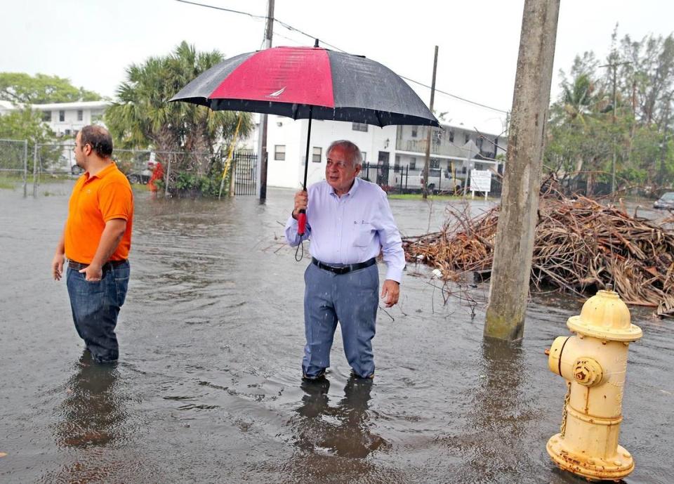 City of Miami Mayor Tomas Regalado and his son Jose Regalado walk through flooded streets in Shorecrest after a combination of rain and king tide flooded the area, October 5, 2017.