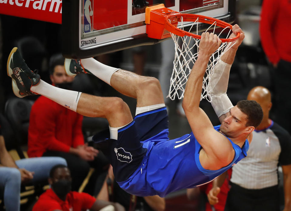 Brook Lopez of the Milwaukee Bucks hangs on the rim after dunking against the Atlanta Hawks. (Photo by Todd Kirkland/Getty Images)