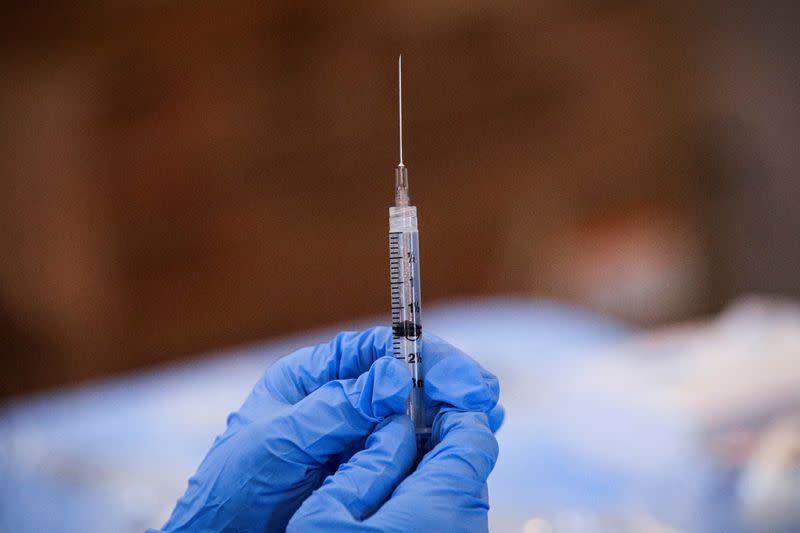 FILE PHOTO: A syringe is filled with a dose of Pfizer's coronavirus disease (COVID-19) vaccine at a pop-up community vaccination center in Valley Stream, New York