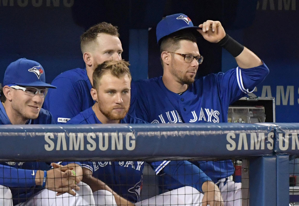 Jul 28, 2019; Toronto, Ontario, CAN;  Toronto Blue Jays former infielder Eric Sogard (5) tips his cap as he bids farewell to former teammates catcher Danny Jansen (left) and right fielder Billy McKinney (obscured) and third baseman Brandon Drury after being traded to Tampa Bay Rays in the third inning during a game against the Rays at Rogers Centre. Mandatory Credit: Dan Hamilton-USA TODAY Sports