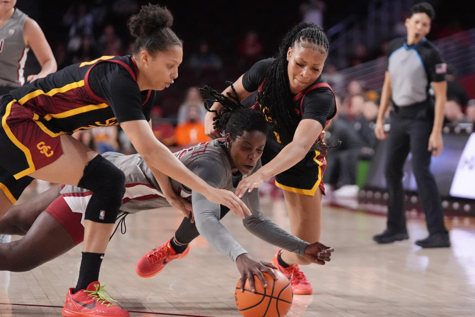 Washington State center Bella Murekatete, center, goes after a loose ball with Southern California forward Kaitlyn Davis, left, and guard Taylor Bigby during the first half of an NCAA college basketball game Friday, Jan. 26, 2024, in Los Angeles. (AP Photo/Mark J. Terrill)