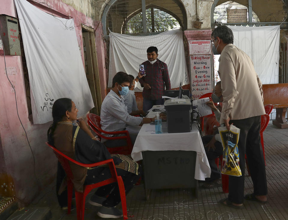 Indians register themselves to receive the Covishield COVID-19 vaccine at a government hospital in Hyderabad, India, Friday, March 12, 2021. Pandemic-weary and sequestered mostly in their homes for a year, India's elderly are now standing in long lines at vaccination sites, then rolling up their sleeves to get shots protecting them against the coronavirus. (AP Photo/Mahesh Kumar A.)