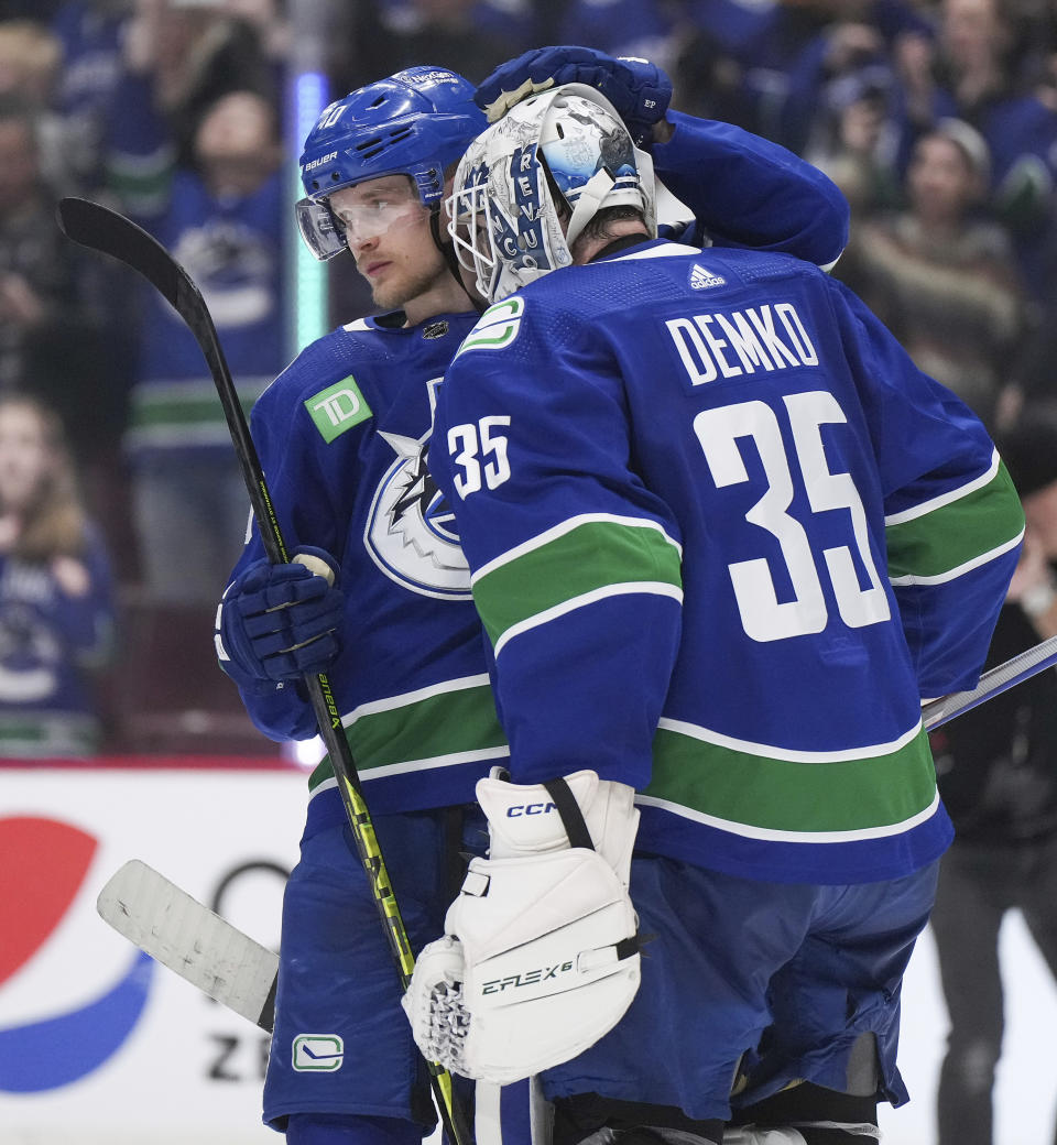 Vancouver Canucks' Elias Pettersson, back left, and goalie Thatcher Demko celebrate after Vancouver defeated the San Jose Sharks in an NHL hockey game in Vancouver, British Columbia, Thursday, March 23, 2023. (Darryl Dyck/The Canadian Press via AP)