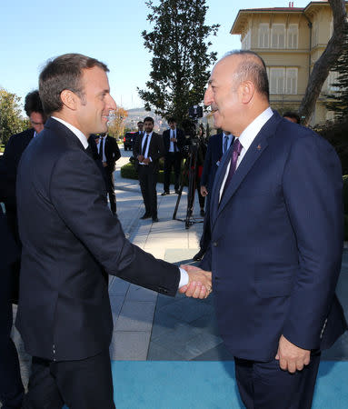 French President Emmanuel Macron shakes hands with Minister of Foreign Affairs of Turkey Mevlut Cavusoglu prior to a summit on Syria, in Istanbul, Turkey October 27, 2018. Cem Oksuz/Pool via REUTERS
