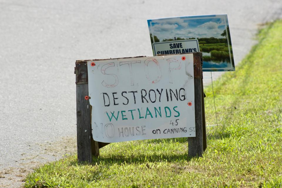 Signs protest Anthony Silva's plan to build a house on property that was almost entirely wetlands at 45 Canning St., Cumberland, R.I.