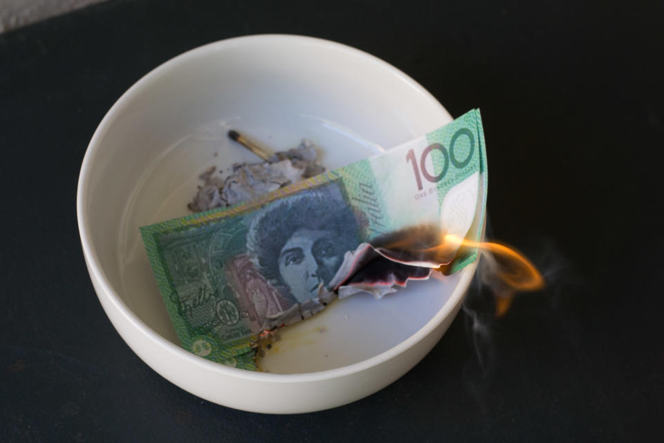 $100 note burning in a bowl