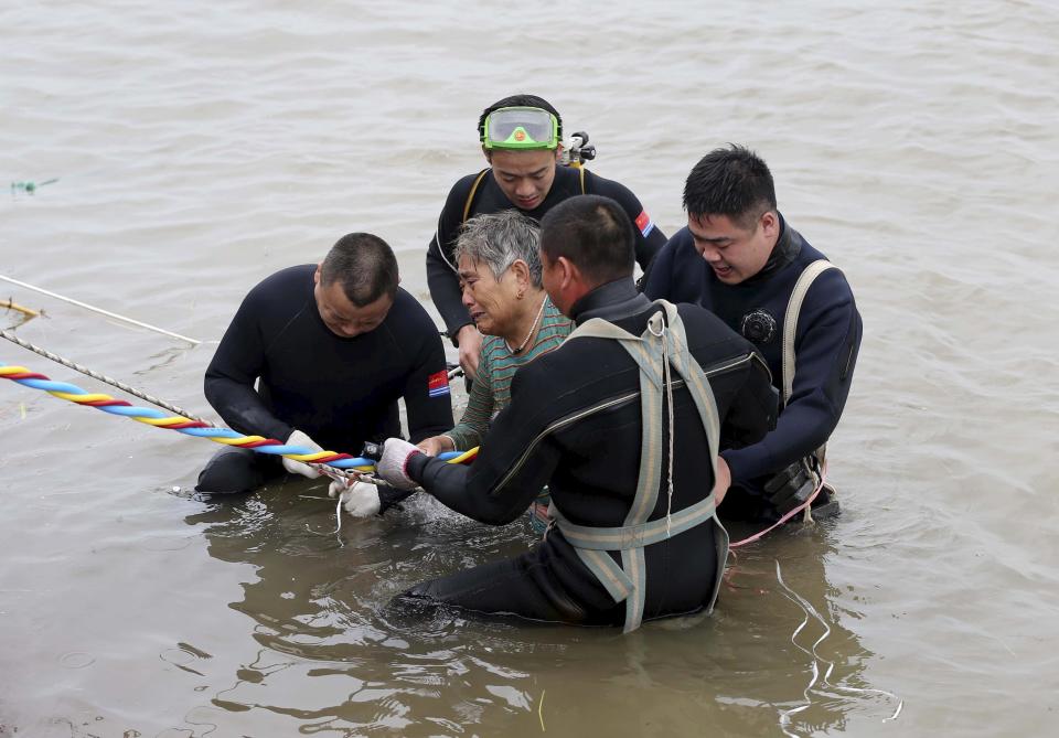 A woman is helped after being pulled out by divers from a sunken ship in Jianli, Hubei province, China, June 2, 2015. Divers pulled the 65-year-old woman from the hull of the passenger ship carrying 458 people that capsized on China's Yangtze River and others could still be alive, state media said on Tuesday. (REUTERS/cnsphoto)