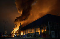 Ukrainian State Emergency Service firefighters put out a fire after Russian shelling hit a shopping center in Kherson, Ukraine, Friday, Feb. 3, 2023. (AP Photo/LIBKOS)