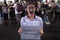 Nalinrat Tuthubthim, 20, a student, who claims she was sexually abused by a teacher, has her mouth covered with tape during a rally in Bangkok