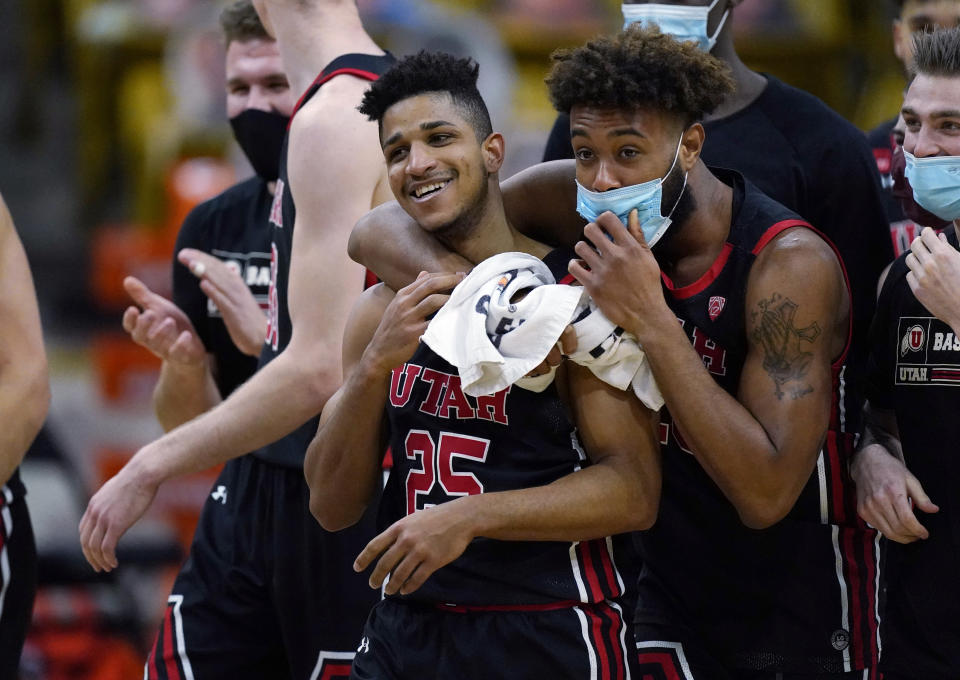 Utah guard Alfonso Plummer, left, is hugged by guard Jordan Kellier as time runs out in the second half of an NCAA college basketball game against Colorado, Saturday, Jan. 30, 2021, in Boulder, Colo. Utah won 77-74. (AP Photo/David Zalubowski)