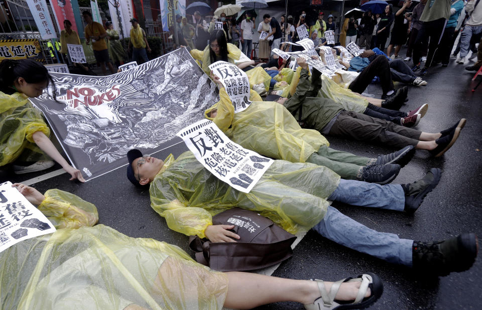 Protesters holding slogans reading ''Oppose the Extension of Dangerous and Old Nuclear Power Plants,'' stage a die-in protest, during an anti-nuclear demonstration in front of Taiwan''s Legislative Yuan in Taipei, Taiwan, Saturday, April 27, 2024. (AP Photo/Chiang Ying-ying)