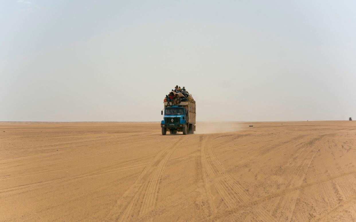 A truck carrying goods and migrants drives through Niger's Tenere desert region of the south central Sahara - AP