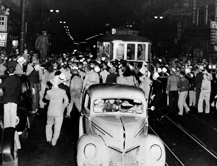 Soldiers, sailors and marines who roamed the street of Los Angeles, June 7, 1943, looking for hoodlums in zoot suits, stopped this streetcar during their search. Crowds jammed downtown streets to watch the service men tear clothing off the zoot suiters they caught. (AP Photo)