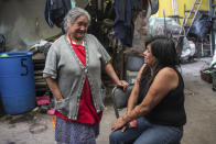 Elisa Xolalpa, who survived an acid attack while tied to a post by her ex-partner 20 years ago when she was 18, talks with her mother Carmen Martinez in the patio of her parent’s home in Mexico City, Saturday, June 12, 2021. Mexico City’s special prosecutor for feminicides, Sayuri Herrera, said that more acid attacks are being registered in Mexico, and that her office is reviewing older cases that were originally classified as serious injuries to see if they can be reclassified as attempted feminicide like Xolalpa’s. (AP Photo/Ginnette Riquelme)