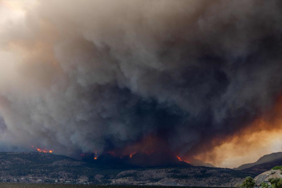 The McDougall Creek wildfire burns in the hills West Kelowna, British Columbia, Canada, on August 17, 2023, as seen from Kelowna. Evacuation orders were put in place for areas near Kelowna, as the fire threatened the city of around 150,000. Canada is experiencing a record-setting wildfire season, with official estimates of over 13.7 million hectares (33.9 million acres) already scorched. Four people have died so far. (Photo by Darren HULL / AFP) (Photo by DARREN HULL/AFP via Getty Images)