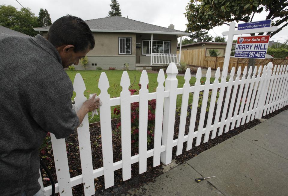 <em>Un hombre coloca una valla en una casa en venta en California. Foto: Paul Sakuma (AP)</em>