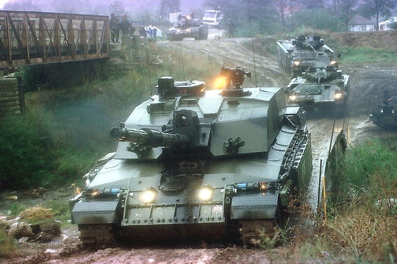 A British Army Challenger 2 tank, with two Warrior infantry fighting vehicles behind it, during operations in Kosovo. <em>Crown Copyright</em>