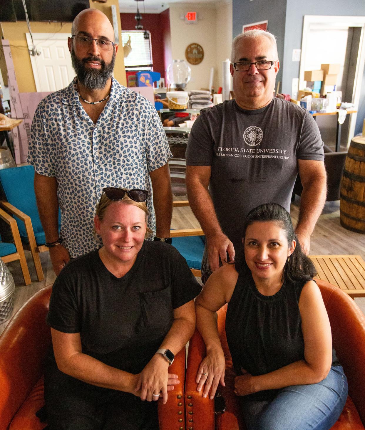 Owners of Growler Country Henry De Valle, Mario Fernandez, Michelle De Valle and Vanessa Fernandez sit in the new location of their restaurant in Killearn Lakes.