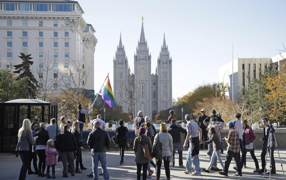 FILE - In this Nov. 14, 2015, file photo, people walk past the Salt Lake Temple after mailing resignation letters during a mass resignation from the Church of Jesus Christ of Latter-day Saints in Salt Lake City. The Church of Jesus Christ of Latter-day Saints is repealing rules unveiled in 2015 that banned baptisms for children of gay parents and made gay marriage a sin worthy of expulsion. The surprise announcement Thursday, April 4, 2019, by the faith widely known as the Mormon church reverses rules that triggered widespread condemations from LGBTQ members and their allies. (AP Photo/Rick Bowmer, File)