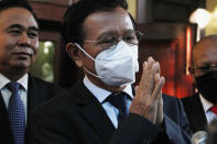 Cambodia National Rescue Party's President Kem Sokha, center, greets to journalists before heading to the court in his house in Phnom Penh, Cambodia, Wednesday, Jan. 19, 2022. A treason trial against Cambodia’s opposition leader resumed Wednesday, two years after it was adjourned due to the coronavirus pandemic. Kem Sokha was head of the Cambodia National Rescue Party when he was arrested in September 2017 on the basis of an old video showing him telling a seminar about receiving advice from U.S. pro-democracy groups. If convicted, he could be sentenced to for up to 30 years' imprisonment. (AP Photo/Heng Sinith)