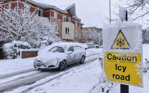  A sign warns of an icy road as a driver navigates his snow covered car down a road in Hockley, Birmingham - Credit: Michael Scott/Caters