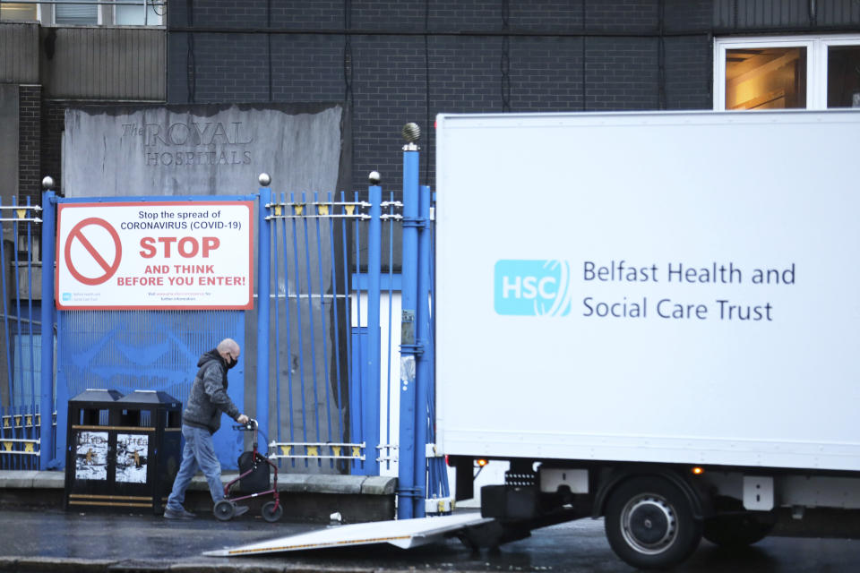 FILE - In this Tuesday, Dec. 8, 2020 file photo, a man enters the Royal Victoria Hospital, one of several hospitals around Britain that are handling the initial phase of a COVID-19 immunization program, in West Belfast, Northern Ireland. Britain races to vaccinate more than 15 million people by mid-February, and in an effort to ensure vaccines get to the right places at the right times, along with the syringes, alcohol swabs and protective equipment needed to administer them, the government has called in the army. (AP Photo/Peter Morrison, File)