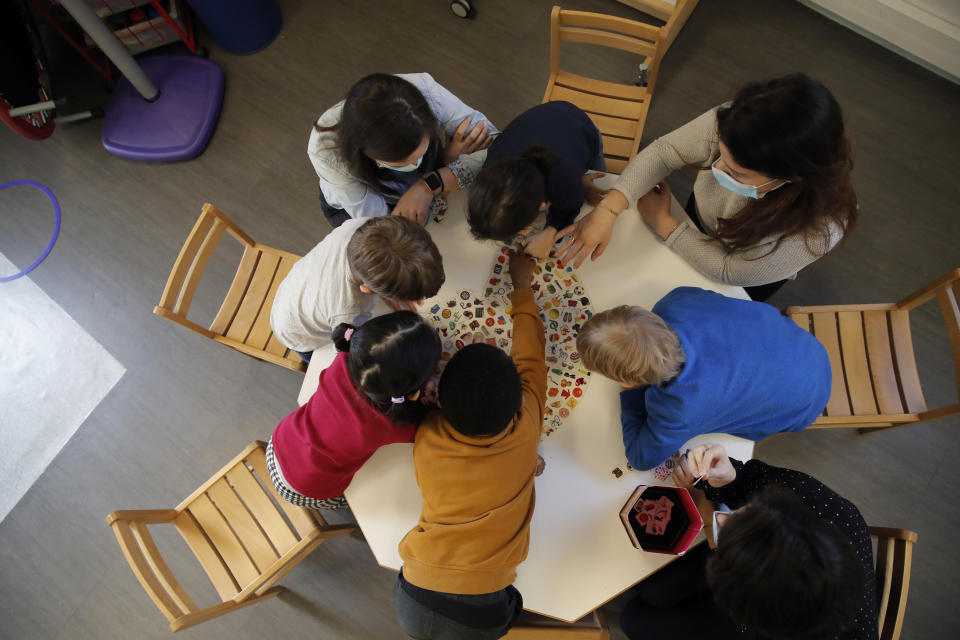 FILE- In this Tuesday, March 2, 2021 file photo, children play with a therapist in the pediatric unit of the Robert Debre hospital, in Paris, France. The UN's child protection agency is urging governments to pour more money and resources into preserving the mental well-being of children and adolescents. UNICEF, in a report released Tuesday, Oct. 5 sounded alarms about blows to mental health from the COVID-19 pandemic that have hit poor and vulnerable children particularly hard. (AP Photo/Christophe Ena, File)