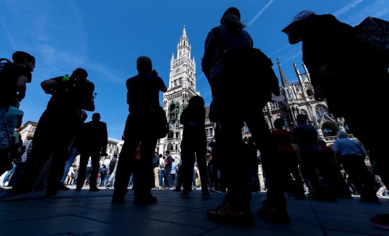 Tourists and locals watch the carillon at Marienplatz in Munich. The out-of-tune bells in the iconic Rathaus Glockenspiel in Munich have prompted a political squabble over what some local politicians call the "disharmony in city hall." Sven Hoppe/dpa