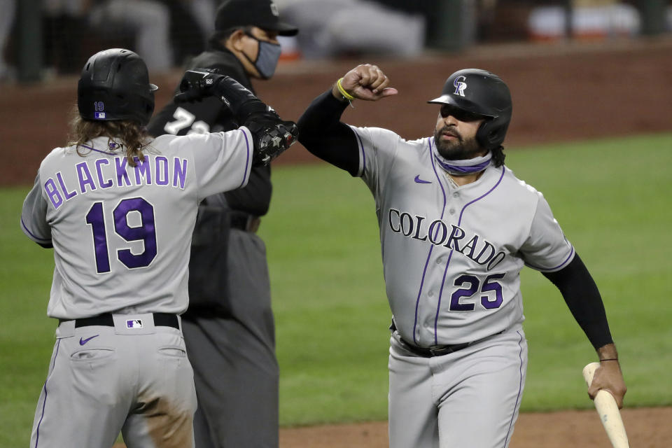 Colorado Rockies' Charlie Blackmon (19) and Matt Kemp (25) share congratulations after both scored against the Seattle Mariners in the sixth inning of a baseball game Friday, Aug. 7, 2020, in Seattle. (AP Photo/Elaine Thompson)