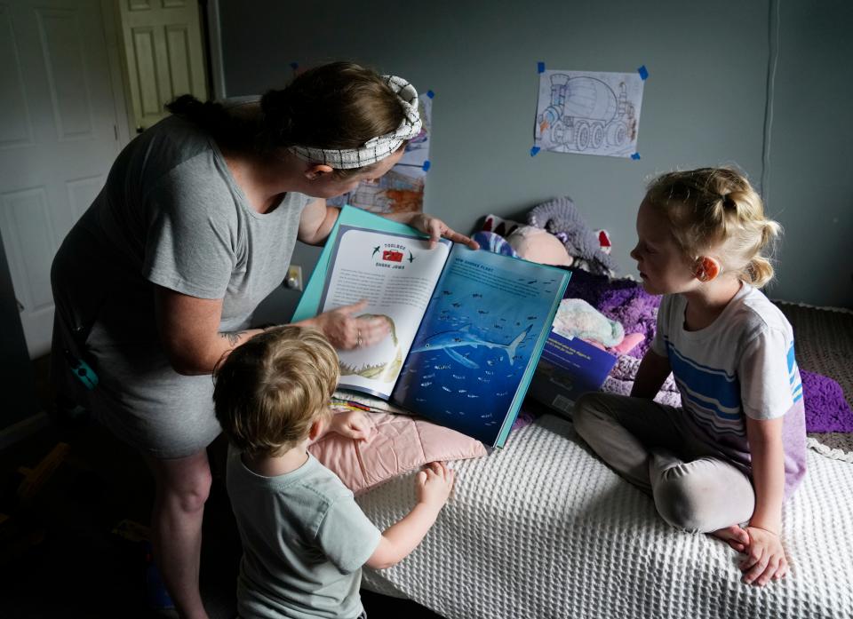 Em Hughes reads to her children, Ben, 5, and Seb, 3, on Monday at her home on Columbus' Far East Side. Hughes is nine weeks pregnant as a first-time surrogate. Her family also includes husband Jeff and German shepherd Oracle.