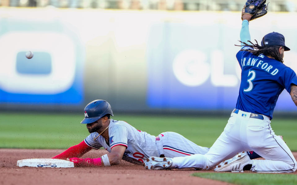 Minnesota Twins' Willi Castro steals second base as Seattle Mariners shortstop J.P. Crawford loses the throw from catcher Cal Raleigh, allowing Max Kepler to score on the error by Raleigh during the third inning of a baseball game Tuesday, July 18, 2023, in Seattle. (AP Photo/Lindsey Wasson)