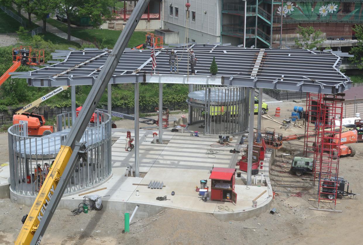 Construction workers atop the Maynard Performance Pavilion secure the final beam at Lock 3 Park on Tuesday, May 7, 2024, in Akron.