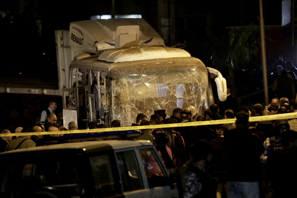 Security forces stand near a tourist bus after a roadside bomb in an area near the Giza Pyramids in Cairo, Egypt, Friday, Dec. 28, 2018. Egypt's Interior Ministry said in a statement that two Vietnamese tourists were killed and others wounded, in the incident.(AP Photo/Nariman El-Mofty)