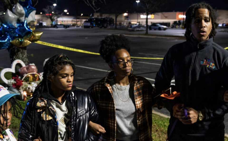 Members of the gun violence activist group, Violence Intervention and Prevention, are pictured praying at a memorial for the victims killed during a shooting at a Walmart store in Chesapeake, Virginia.